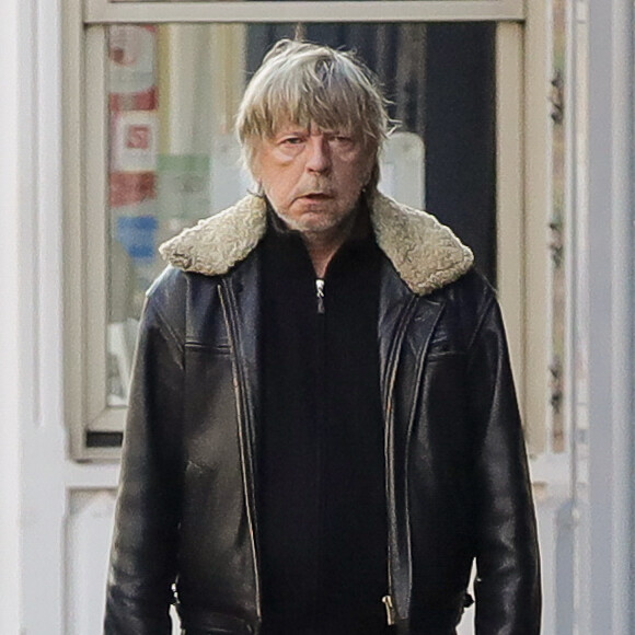 Exclusif - Le chanteur Renaud retire de l'argent à un distributeur et donne un billet à un mendiant à Paris le 13 février 2017.