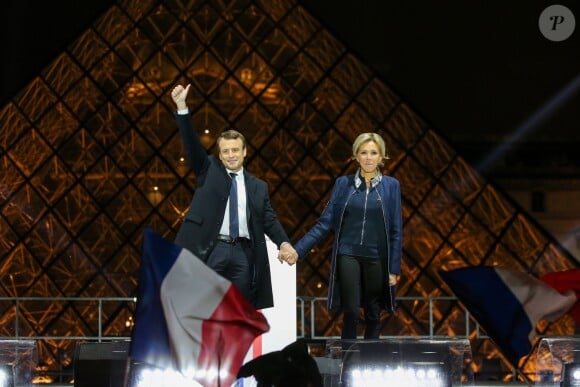 Emmanuel Macron, élu président de la république, et sa femme Brigitte Macron (Trogneux), saluent les militants devant la pyramide au musée du Louvre à Paris, après sa victoire lors du deuxième tour de l'élection présidentielle. Le 7 mai 2017.