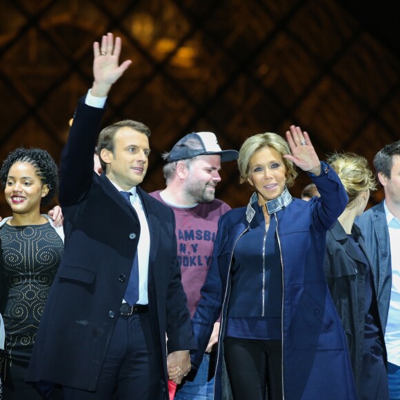 Morgan Simon (l'homme à la casquette), Emmanuel Macron, élu président de la république, et sa femme Brigitte Macron (Trogneux), saluent les militants devant la pyramide au musée du Louvre à Paris, après sa victoire lors du deuxième tour de l'élection présidentielle. Le 7 mai 2017.