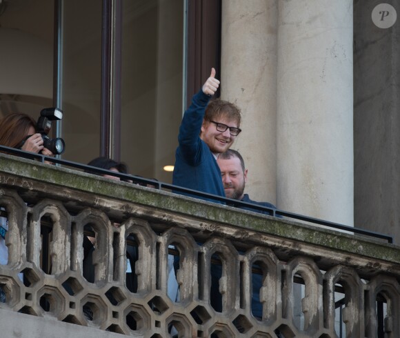 Ed Sheeran salue ses fans depuis le balcon Mondadori Megastore de la piazza del Duomo à Milan, le 12 mars 2017.