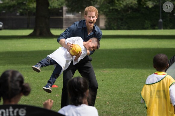 Le prince Harry joue lors de sa visite avec des enfants du camp d'été centre de loisirs Newham Council's à Central Park à Londres, le 28 juillet 2017.