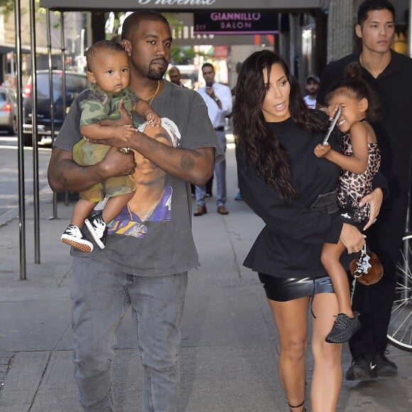 Kim Kardashian et son mari Kanye West dans les rues de New York avec leurs enfants North et Saint dans les bras, le 29 août 2016.