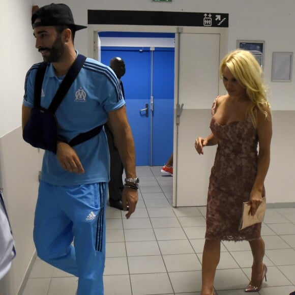 Pamela Anderson et Adil Rami, le bras en écharpe suite à sa blessure au pectoral, à la sortie des vestiaires du Stade Vélodrome à Marseille le 24 août 2017 à l'issue du match de barrage retour d'Europa League entre l'OM et Domzale, première rencontre à laquelle l'Américaine venait assister. © Eric Etten/Bestimage