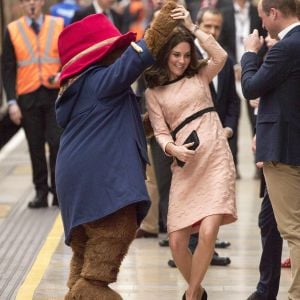 Kate Middleton, enceinte et vêtue d'une robe Orla Kiely, s'est laissé entraîner dans une danse par l'ours Paddington sur le quai de la gare de Paddington, à Londres le 16 octobre 2017, lors d'un événement du Charities Forum auquel elle prenait part avec le prince William et le prince Harry.