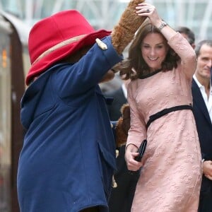 Kate Middleton, enceinte et vêtue d'une robe Orla Kiely, s'est laissé entraîner dans une danse par l'ours Paddington sur le quai de la gare de Paddington, à Londres le 16 octobre 2017, lors d'un événement du Charities Forum auquel elle prenait part avec le prince William et le prince Harry.