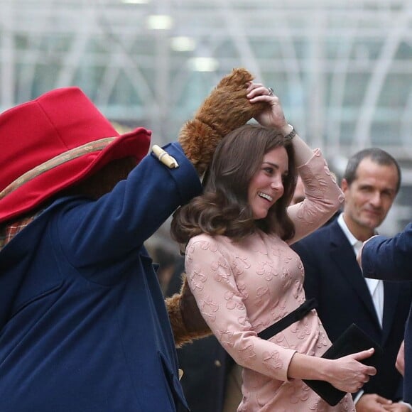 Kate Middleton, enceinte et vêtue d'une robe Orla Kiely, s'est laissé entraîner dans une danse par l'ours Paddington sur le quai de la gare de Paddington, à Londres le 16 octobre 2017, lors d'un événement du Charities Forum auquel elle prenait part avec le prince William et le prince Harry.