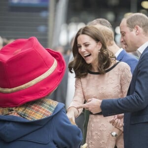 Kate Middleton, enceinte et vêtue d'une robe Orla Kiely, s'est laissé entraîner dans une danse par l'ours Paddington sur le quai de la gare de Paddington, à Londres le 16 octobre 2017, lors d'un événement du Charities Forum auquel elle prenait part avec le prince William et le prince Harry.