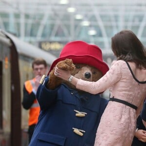 Kate Middleton, enceinte et vêtue d'une robe Orla Kiely, s'est laissé entraîner dans une danse par l'ours Paddington sur le quai de la gare de Paddington, à Londres le 16 octobre 2017, lors d'un événement du Charities Forum auquel elle prenait part avec le prince William et le prince Harry.