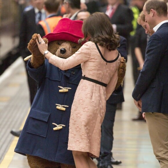 Kate Middleton, enceinte et vêtue d'une robe Orla Kiely, s'est laissé entraîner dans une danse par l'ours Paddington sur le quai de la gare de Paddington, à Londres le 16 octobre 2017, lors d'un événement du Charities Forum auquel elle prenait part avec le prince William et le prince Harry.