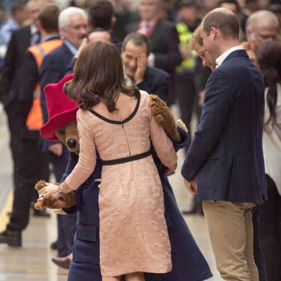 Kate Middleton, enceinte et vêtue d'une robe Orla Kiely, s'est laissé entraîner dans une danse par l'ours Paddington sur le quai de la gare de Paddington, à Londres le 16 octobre 2017, lors d'un événement du Charities Forum auquel elle prenait part avec le prince William et le prince Harry.