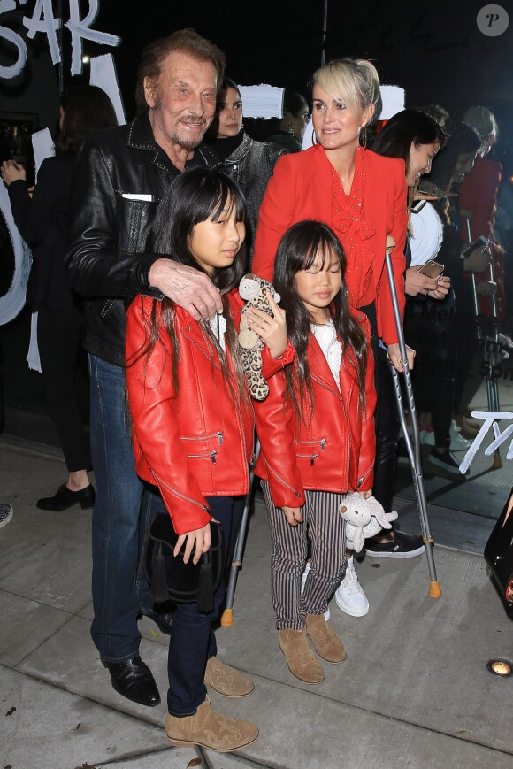 Johnny Hallyday, sa femme Laeticia (en béquilles) et leurs filles Jade et Joy au vernissage de l'exposition du photographe Mathieu Cesar à Los Angeles.