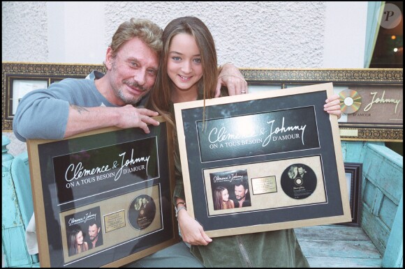Exclusif - Johnny Hallyday et Clémence posent avec leur disque d'or pour la chanson "On a tous besoin d'amour" le 23 septembre 2002.