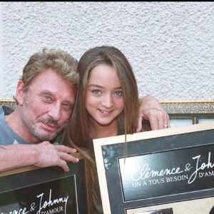 Exclusif - Johnny Hallyday et Clémence posent avec leur disque d'or pour la chanson "On a tous besoin d'amour" le 23 septembre 2002.