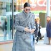 Kendall Jenner se promène dans les rues de New York. Le mannequin porte un jean troué, un large manteau gris à carreaux et des baskets 'Yeezy boost 700' , le 20 novembre 2017.