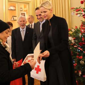 Semi-Exclusif - La princesse Charlene de Monaco remettant un cadeau et la carte de voeux figurant la photo de ses enfants Jacques et Gabriella lors de la traditionnelle distribution de cadeaux de Noël aux personnes âgées monégasques au siège de la Croix Rouge de Monaco le 15 décembre 2017. © Claudia Albuquerque / Bestimage