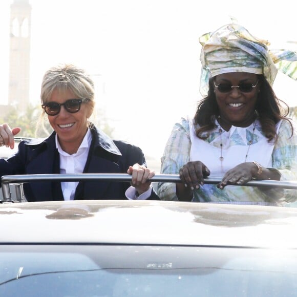 Brigitte Macron, Marème Sall - Après avoir été accueillis par le Président de la République du Sénégal, Macky Sall et son épouse Marène Sall sur l'aéroport de Saint-Louis, le Président de la République française, Emmanuel Macron accompagné de son épouse Brigitte Macron ont participé à un bain de foule dans les rues de la ville. Ils se sont, ensuite, rendus sur la Langue de Barbarie, touchée par l'érosion côtière avant d'aller sur la place Faidherbe pour une allocution des deux chefs d'états. Avant de quitter Saint-Louis, le couple présidentiel est allé à la rencontre des élèves d'une école à l'occasion du lancement symbolique d'un concours sur les cent ans de l'Aéropostale. Saint-Louis, Sénégal le le 3 Février 2018. © Dominique Jacovides/Bestimage