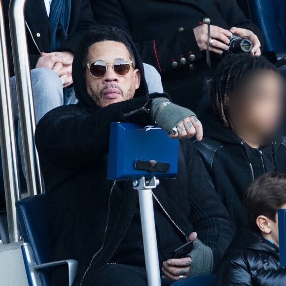 JoeyStarr et ses fils Mathis et Khalil dans les tribunes du match PSG - Strasbourg (5-2) au Parc des Princes à Paris le 17 février 2018.