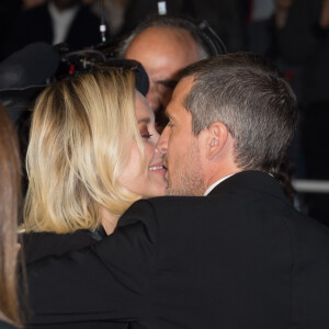 Guillaume Canet et Marion Cotillard s'embrassent amoureusement à la descente des marches pour le film Le Grand Bain à Cannes, le 13 mai 2018.