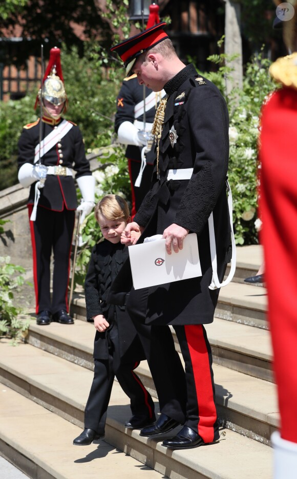 Le prince George de Cambridge, petit "pageboy" vêtu d'une réplique de l'uniforme des Blues and Royals porté par le prince Harry et le prince William, avec son père le duc de Cambridge au mariage du prince Harry et de Meghan Markle, à la sortie de la chapelle St George à Windsor le 19 mai 2018.
