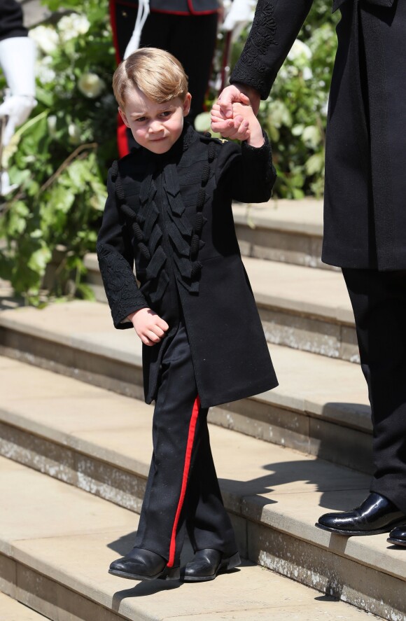 Le prince George de Cambridge, petit "pageboy" vêtu d'une réplique de l'uniforme des Blues and Royals porté par le prince Harry et le prince William, au mariage du prince Harry et de Meghan Markle, à la sortie de la chapelle St George à Windsor le 19 mai 2018.