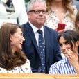 La duchesse Catherine de Cambridge (Kate Middleton) et la duchesse Meghan de Sussex (Meghan Markle) complices dans la royal box à Wimbledon le 14 juillet 2018.