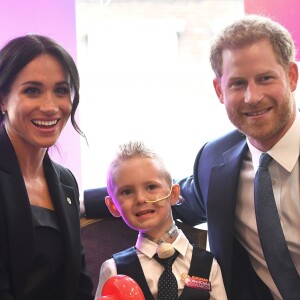 Le prince Harry, duc de Sussex, et Meghan Markle, duchesse de Sussex, posent avec le jeune Mckenzie lors de leur rencontre avec les lauréats des WellChild Awards lors d'une réception avant le gala annuel de l'association WellChild à l'hôtel Royal Dorchester à Londres le 4 septembre 2018.