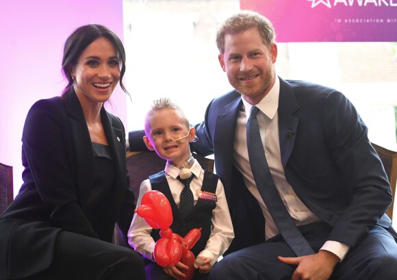 Le prince Harry, duc de Sussex, et Meghan Markle, duchesse de Sussex, posent avec le jeune Mckenzie lors de leur rencontre avec les lauréats des WellChild Awards lors d'une réception avant le gala annuel de l'association WellChild à l'hôtel Royal Dorchester à Londres le 4 septembre 2018.