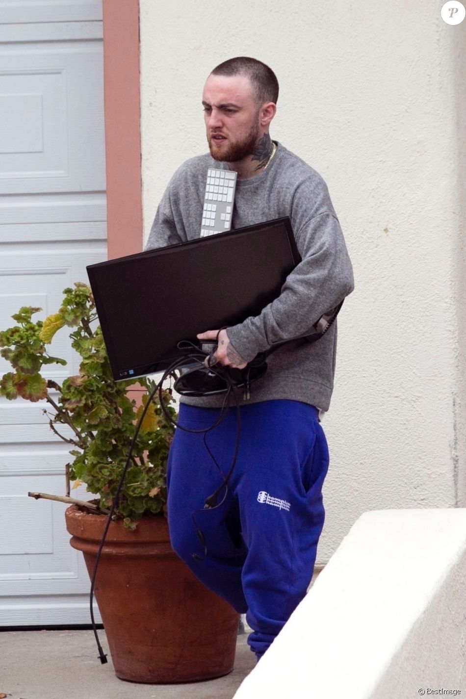Mac Miller sort de sa voiture avec un ordinateur dans les mains à Los Angeles le 3 mars 2018.