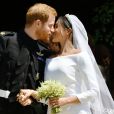 Le prince Harry et Meghan Markle (en robe de mariée Givenchy), duc et duchesse de Sussex, échangeant un baiser à la sortie de chapelle St. George au château de Windsor après leur mariage le 19 mai 2018.