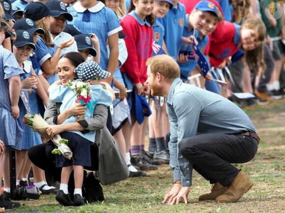 Le prince Harry, duc de Sussex et sa femme Meghan Markle, duchesse de Sussex (enceinte) sont accueillis par des élèves australiens à leur arrivée à Dubbo en Australie dans le cadre de leur première tournée officielle, le 17 octobre 2018.