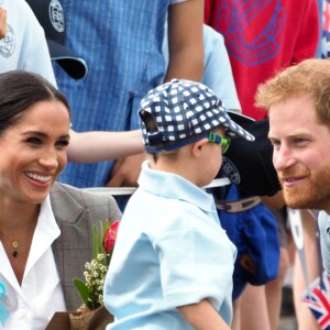 Le prince Harry, duc de Sussex et sa femme Meghan Markle, duchesse de Sussex (enceinte) sont accueillis par des élèves australiens à leur arrivée à Dubbo en Australie dans le cadre de leur première tournée officielle, le 17 octobre 2018.