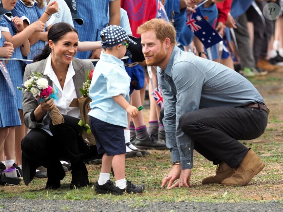 Le prince Harry, duc de Sussex et sa femme Meghan Markle, duchesse de Sussex (enceinte) sont accueillis par des élèves australiens à leur arrivée à Dubbo en Australie dans le cadre de leur première tournée officielle, le 17 octobre 2018.