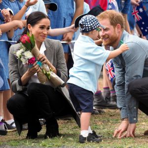 Le prince Harry, duc de Sussex et sa femme Meghan Markle, duchesse de Sussex (enceinte) sont accueillis par des élèves australiens à leur arrivée à Dubbo en Australie dans le cadre de leur première tournée officielle, le 17 octobre 2018.