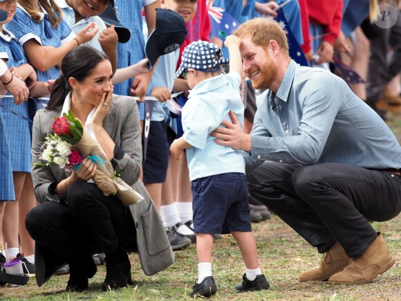 Le prince Harry, duc de Sussex et sa femme Meghan Markle, duchesse de Sussex (enceinte) sont accueillis par des élèves australiens à leur arrivée à Dubbo en Australie dans le cadre de leur première tournée officielle, le 17 octobre 2018.