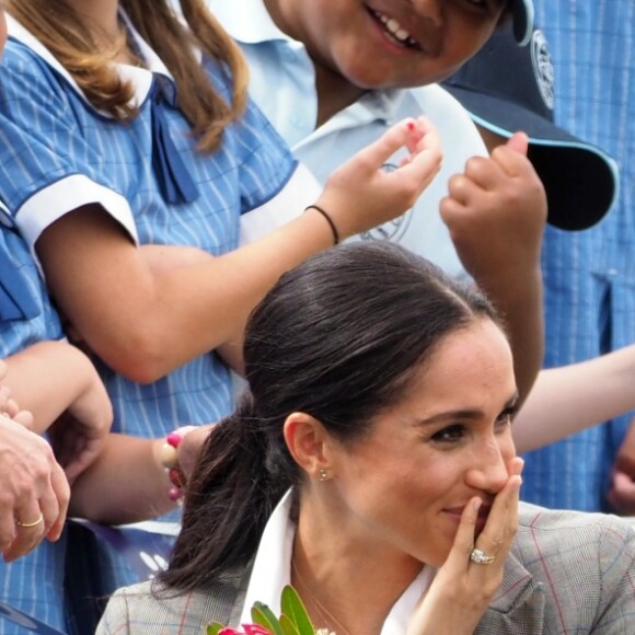 Le prince Harry, duc de Sussex et sa femme Meghan Markle, duchesse de Sussex (enceinte) sont accueillis par des élèves australiens à leur arrivée à Dubbo en Australie dans le cadre de leur première tournée officielle, le 17 octobre 2018.