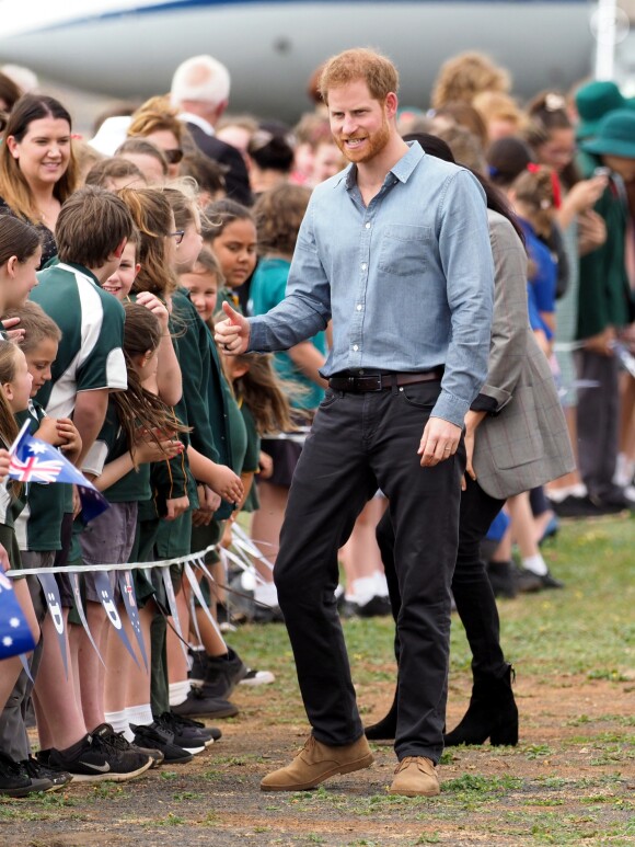 Le prince Harry, duc de Sussex et sa femme Meghan Markle, duchesse de Sussex (enceinte) sont accueillis par des élèves australiens à leur arrivée à Dubbo en Australie dans le cadre de leur première tournée officielle, le 17 octobre 2018.