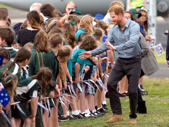 Le prince Harry, duc de Sussex et sa femme Meghan Markle, duchesse de Sussex (enceinte) sont accueillis par des élèves australiens à leur arrivée à Dubbo en Australie dans le cadre de leur première tournée officielle, le 17 octobre 2018.