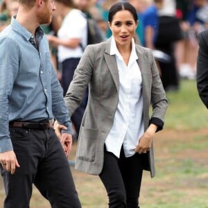 Le prince Harry, duc de Sussex et sa femme Meghan Markle, duchesse de Sussex (enceinte) sont accueillis par des élèves australiens à leur arrivée à Dubbo en Australie dans le cadre de leur première tournée officielle, le 17 octobre 2018.