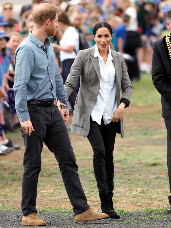 Le prince Harry, duc de Sussex et sa femme Meghan Markle, duchesse de Sussex (enceinte) sont accueillis par des élèves australiens à leur arrivée à Dubbo en Australie dans le cadre de leur première tournée officielle, le 17 octobre 2018.
