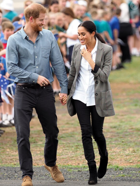 Le prince Harry, duc de Sussex et sa femme Meghan Markle, duchesse de Sussex (enceinte) sont accueillis par des élèves australiens à leur arrivée à Dubbo en Australie dans le cadre de leur première tournée officielle, le 17 octobre 2018.