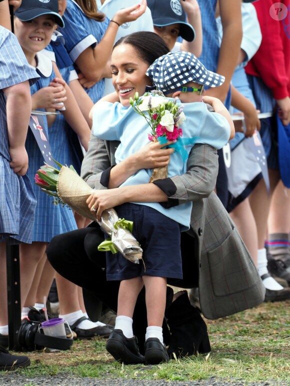 Le prince Harry, duc de Sussex et sa femme Meghan Markle, duchesse de Sussex (enceinte) sont accueillis par des élèves australiens à leur arrivée à Dubbo en Australie dans le cadre de leur première tournée officielle, le 17 octobre 2018.