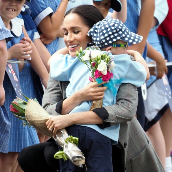 Le prince Harry, duc de Sussex et sa femme Meghan Markle, duchesse de Sussex (enceinte) sont accueillis par des élèves australiens à leur arrivée à Dubbo en Australie dans le cadre de leur première tournée officielle, le 17 octobre 2018.