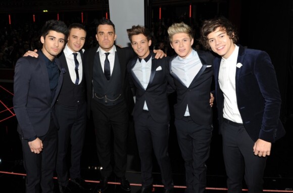 Les One Direction reçus par la reine Elizabeth II, accompagnés par Robbie Williams, à Londres le 19 novembre 2012.
