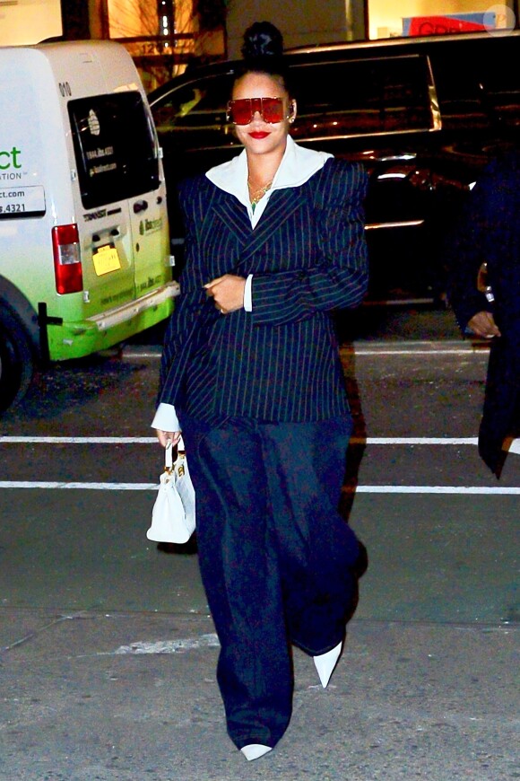 Rihanna porte une veste rayée et des lunettes de soleil XXL en balade dans les rues de New York, le 13 janvier 2019.