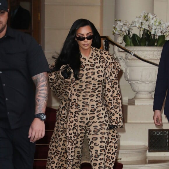 Kim Kardashian porte une combinaison, des chaussures et un manteau léopard ALAÏA à la sortie de l'hôtel Ritz. Paris, le 5 mars 2019.