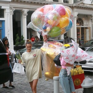 Bella Hadid arrive les bras chargés de ballons et fleurs au domicile de sa soeur Gigi Hadid pour son anniversaire à New York, le 23 avril 2019.