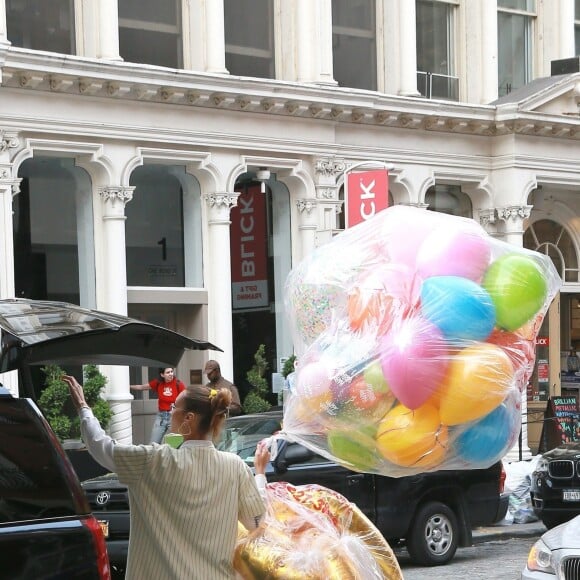 Bella Hadid arrive les bras chargés de ballons et fleurs au domicile de sa soeur Gigi Hadid pour son anniversaire à New York, le 23 avril 2019.