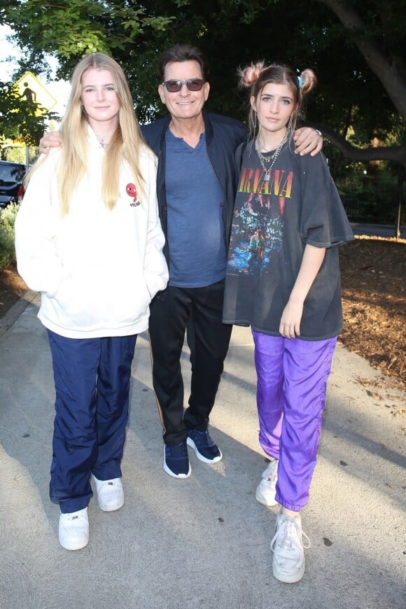 Charlie Sheen pose avec ses filles alors qu'il arrive au concert de Billie Eilish au théâtre Greek à Los Angeles, le 11 juillet 2019.