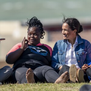 Le prince Harry, duc de Sussex, et Meghan Markle, duchesse de Sussex rencontrent les membres de "Waves for Change" un organisme de bienfaisance qui travaille avec les surfeurs locaux sur la plage de Monwabisi au Cap lors de leur 2ème journée en Afrique du Sud, le 24 septembre 2019.