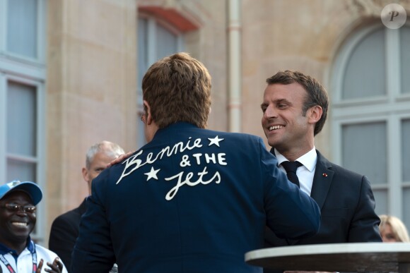 Elton John, Emmanuel Macron, président de la République - Après avoir remis la légion d'honneur à E.John, E.Macron lance en présence de la star la Fête de la Musique au Palais de l'Elysée. Pour l'occasion la cours est ouverte au public et des groupes de musique exclusivement féminins ont été invités. Un appel à la mobilisation internationale pour accroître les fonds de la lutte contre le sida, le paludisme et la tuberculose a également été lancé au cours de l'évènement. Paris, le 21 juin 2019. © Xavier Popy / Pool / Bestimage